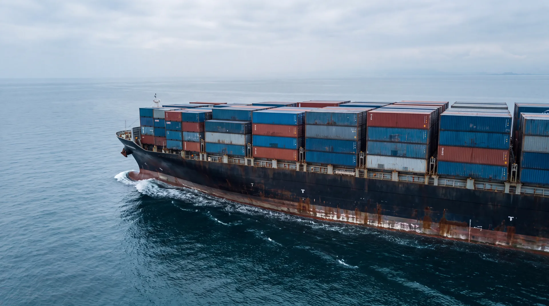 Volgeladen containerschip van opzij over de volle lengte, open lucht erboven
